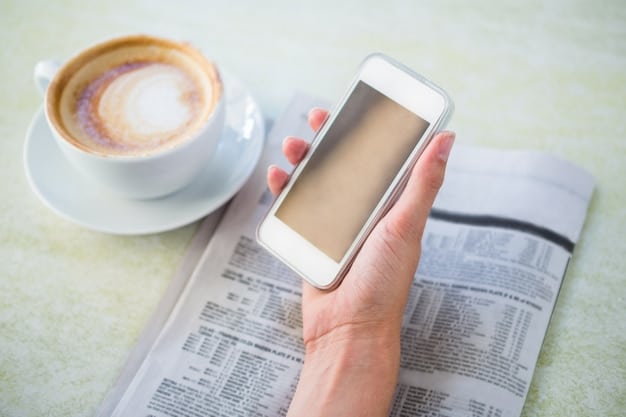 A person holding a smartphone displaying a news article about the Affordable Connectivity Program. The background is a blurred coffee shop setting, suggesting the person is casually reading the news.