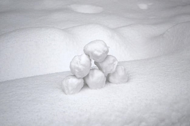 A visual representation of the debt snowball method, showing a snowball rolling down a hill and growing larger as it accumulates more snow. The snowball is labeled with the increasing debt amounts being paid off.