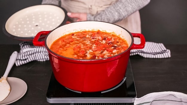 A close-up shot of a large pot of hearty vegetable stew simmering on the stovetop, highlighting the vibrant colors of the different vegetables and the rich, flavorful broth. A wooden spoon rests on the side, ready to stir the comforting and budget-friendly meal.