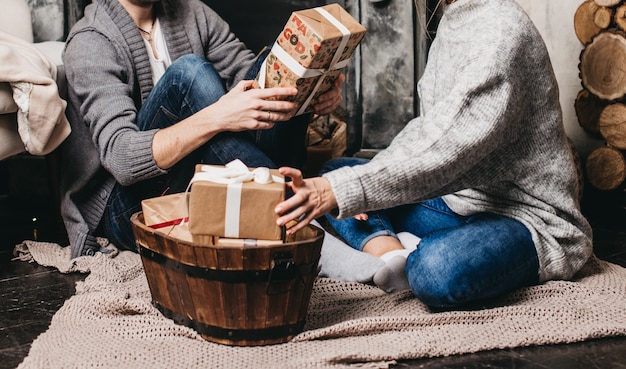 A group of friends exchanging handmade gifts during a cozy holiday gathering. The scene should highlight the warmth and personal touch of homemade gifts, emphasizing the joy of giving over the cost of the present.