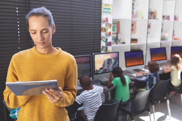 A student using a tablet in a classroom, with educational software displaying interactive content. The student is focused and engaged, and the background shows other students also using technology.