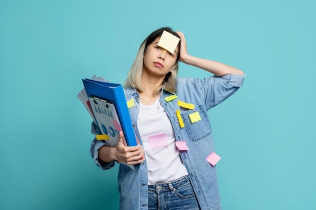 A person holding their head in their hands, looking stressed while surrounded by student loan documents and a calculator.