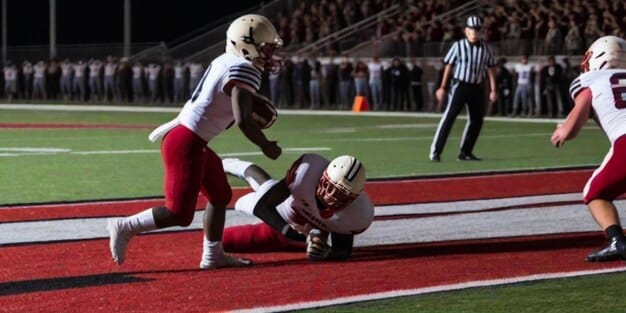 A dynamic action shot of a college football running back breaking through a tackle, showcasing strength and agility on a verdant field, with blurred defenders in the background emphasizing speed.