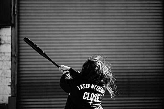 A close-up action shot of a lacrosse player catching the ball in their stick, with a blurred, dynamic background of other players and the field, emphasizing the speed and skill required in the sport.
