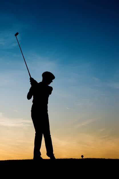 A professional golfer in mid-swing, silhouetted against a setting sun, demonstrating peak physical performance.