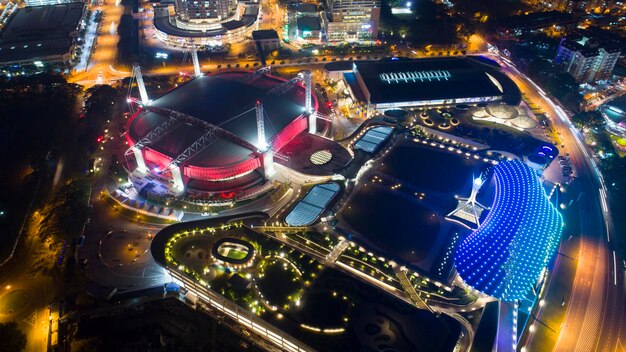 An aerial shot of the Oakland Arena at dusk, with city lights beginning to twinkle, emphasizing its readiness to host a major basketball event.