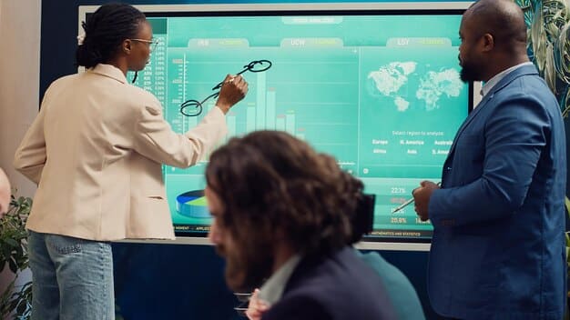 A diverse team of business professionals collaborating around a large touchscreen displaying interactive data visualizations, symbolizing innovation and strategy.