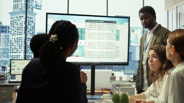 A diverse team of employees gathered around a large monitor, actively collaborating on a digital dashboard showing risk assessment and mitigation strategies, representing proactive business planning.