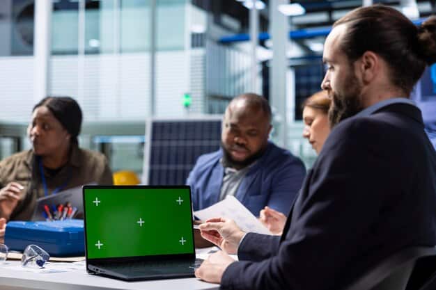 A diverse group of financial professionals looking at charts and models on screens, with green energy symbols subtly integrated into the office environment, representing sustainable finance.