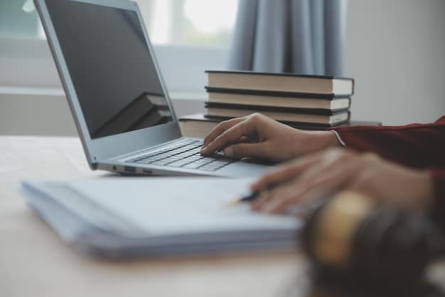 A close-up of hands typing on a laptop, surrounded by books and application forms, set in a comfortable study environment, symbolizing diligent scholarship application work.