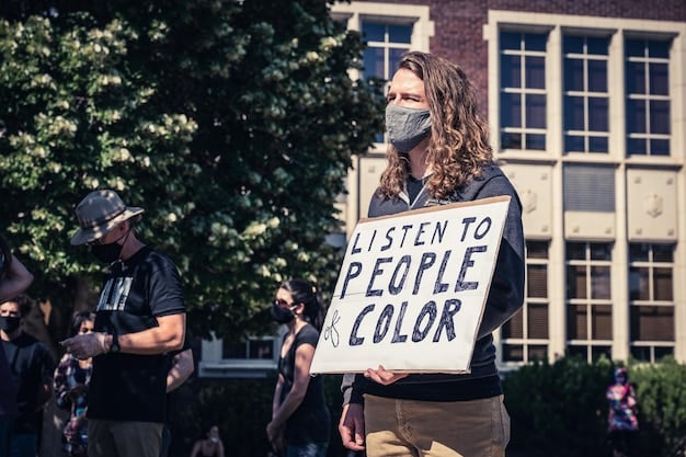 A diverse group of teachers protesting outside a state capitol building, holding signs advocating for higher teacher salaries and better funding for public education. The mood is determined but hopeful.