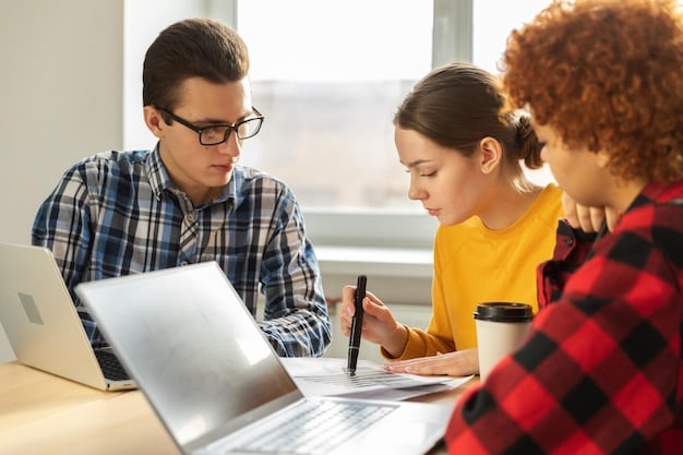 A high school student and their parent sitting at a desk, looking at a laptop and discussing a document, symbolizing collaborative planning and academic guidance.