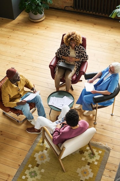 A diverse group of students sitting in a circle, participating in a workshop. They are engaged in a discussion about empathy and online behavior, with a facilitator guiding the conversation. The atmosphere is supportive and collaborative, reflecting a commitment to creating a positive online environment.