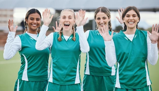 Group photo of U.S. Women's National Team players celebrating a major victory, with confetti falling and jubilant expressions, showcasing their success and teamwork.