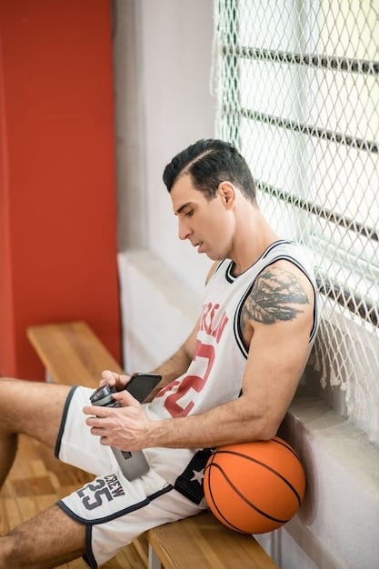 A close-up shot of a college basketball player signing an autograph on a basketball, with a local business logo subtly displayed in the background. The image captures the direct interaction between the athlete and their endorsement deal, symbolizing the opportunities created by NCAA NIL Deals: How Are They Impacting College Athletics in 2025?.