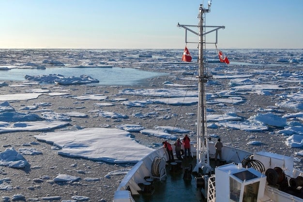 A Coast Guard icebreaker navigating through partially open Arctic waters, with scientific equipment visible on deck, symbolizing the dual challenge of access and environmental monitoring.