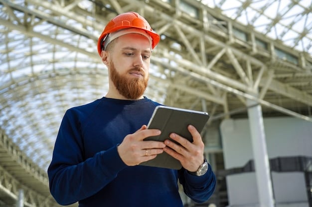 A medium shot of an engineer in a US factory using a tablet to monitor the performance of a 3D printer. The engineer is wearing safety glasses and appears focused on the screen. In the background, a 3D printer is creating a complex component, visualizing the integration of technology and human expertise.